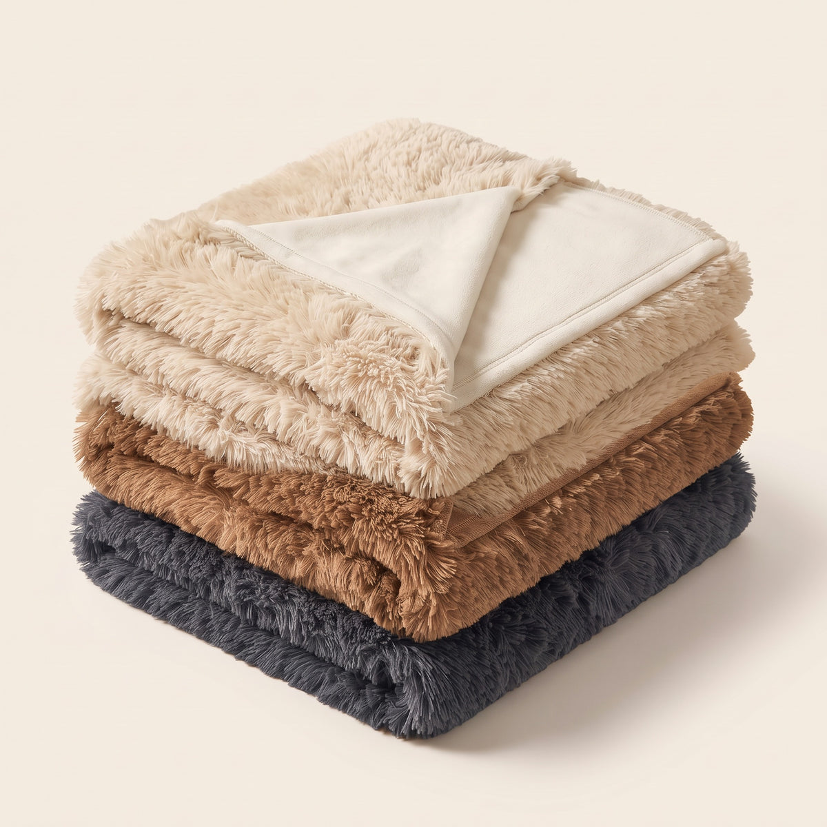 Cosy Blanket folded in all three colours: Beige, Camel and Dark Grey